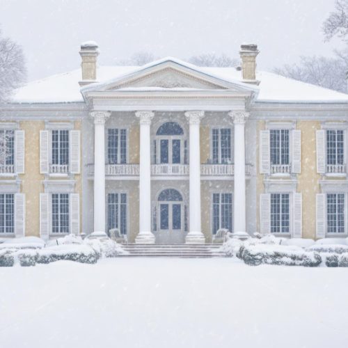 front view of a fancy two story house with yellow walls covered under snow