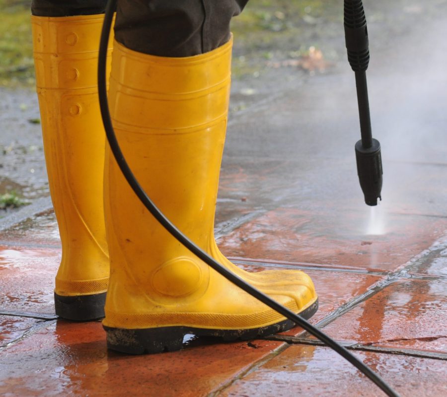 picture of feet's of a man pressure washing the floor